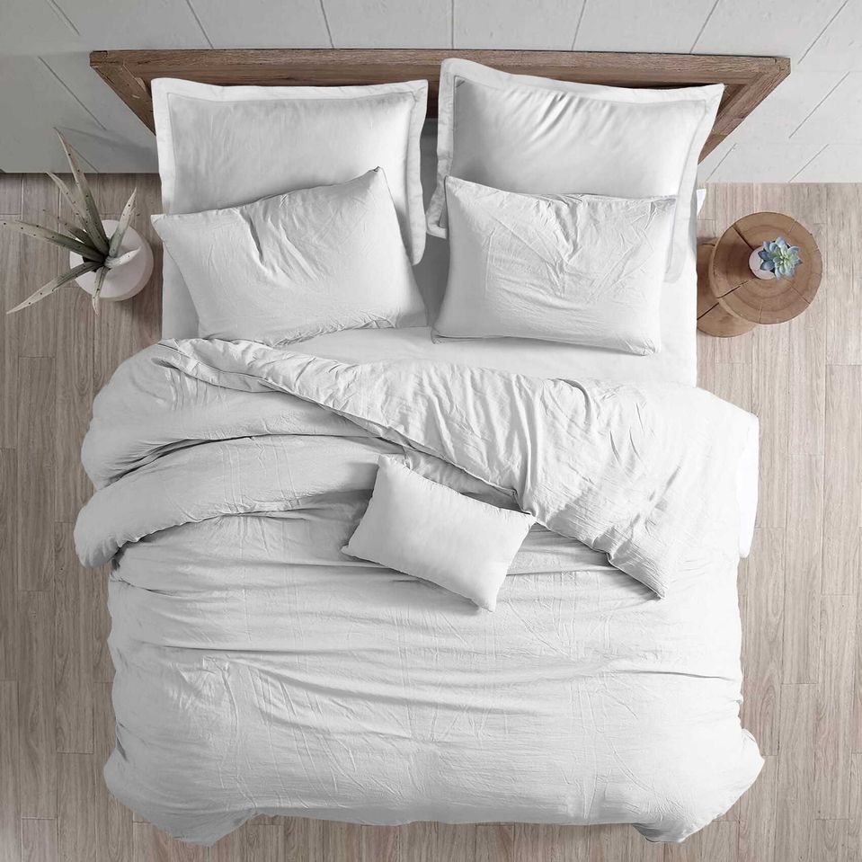 Ein Bett mit weißer Bettwäsche